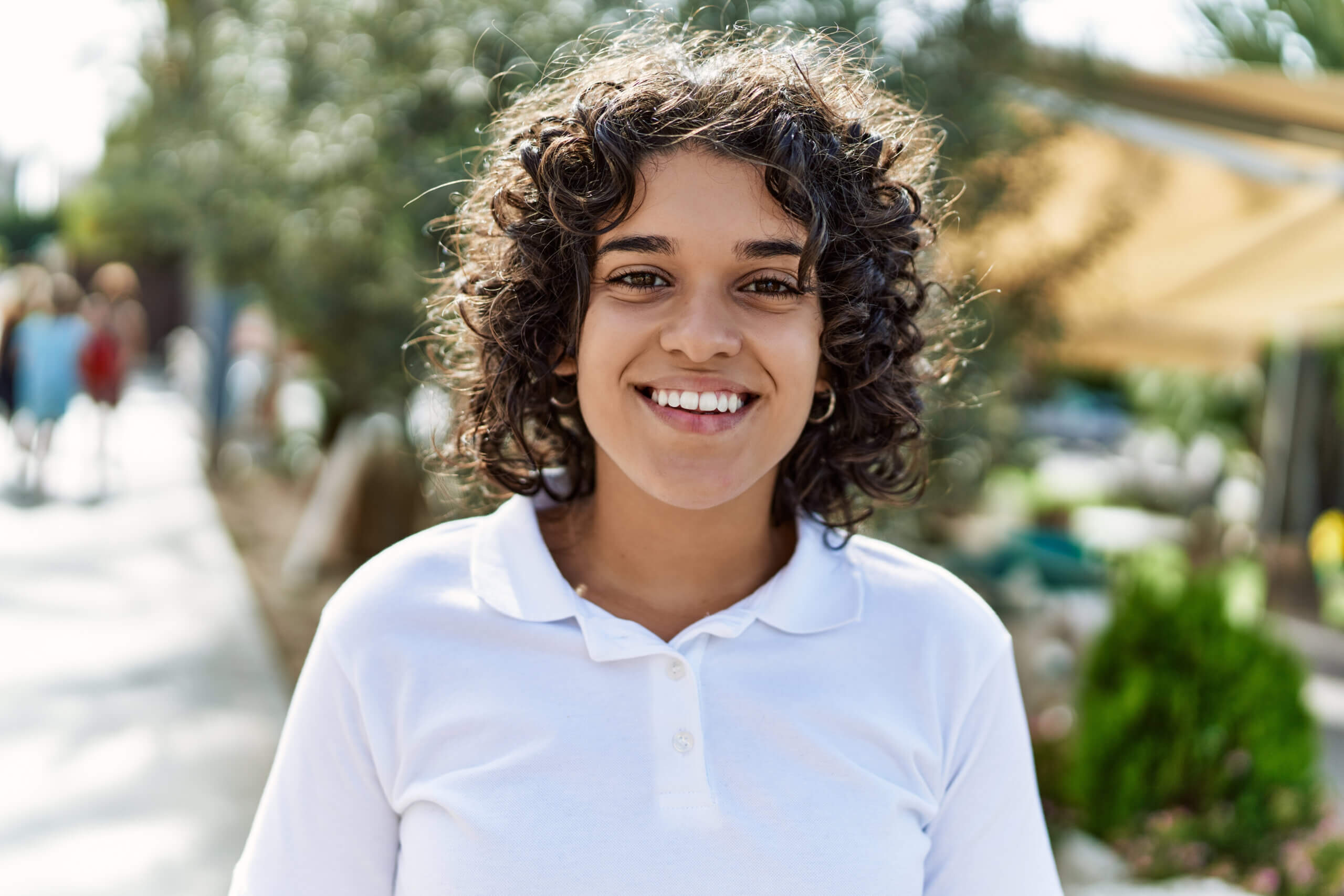 Young latin girl smiling happy standing at the city.